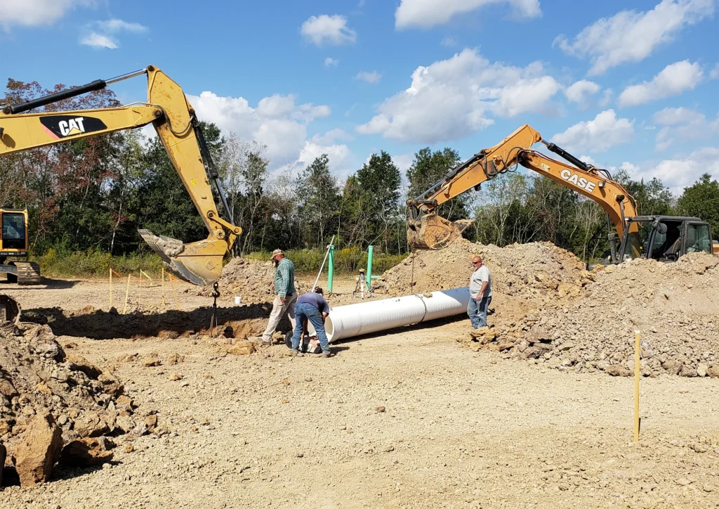 excavators-and-man-fixing-white-pipe