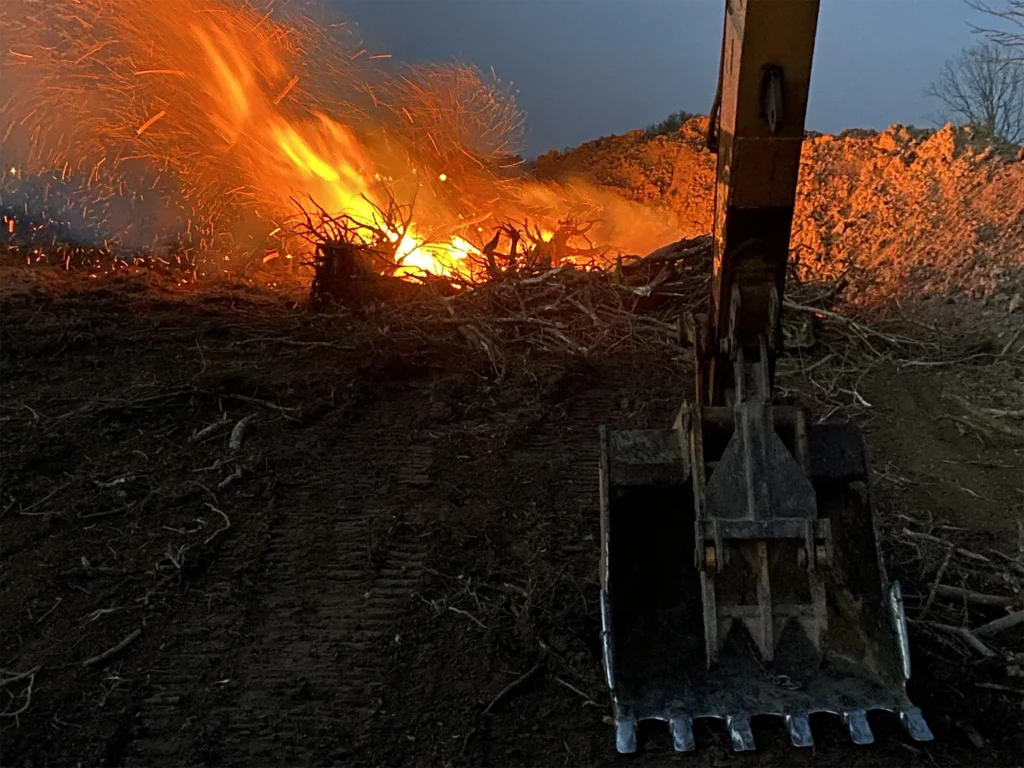 excavator-with-branches-on-fire