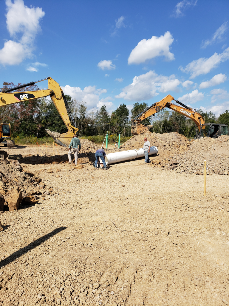 excavators-and-man-fixing-white-pipe